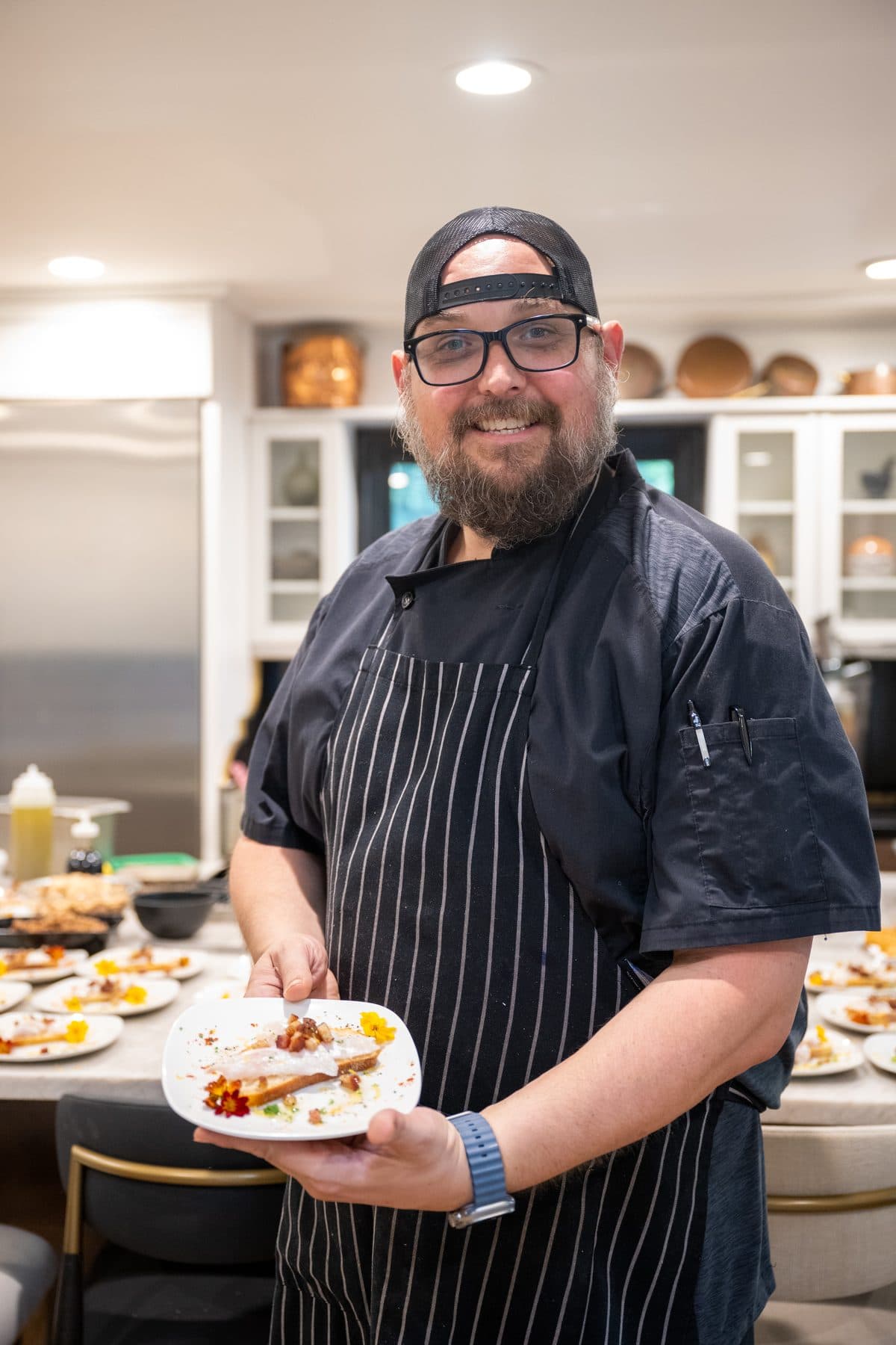 A chef presenting a plated course to the table