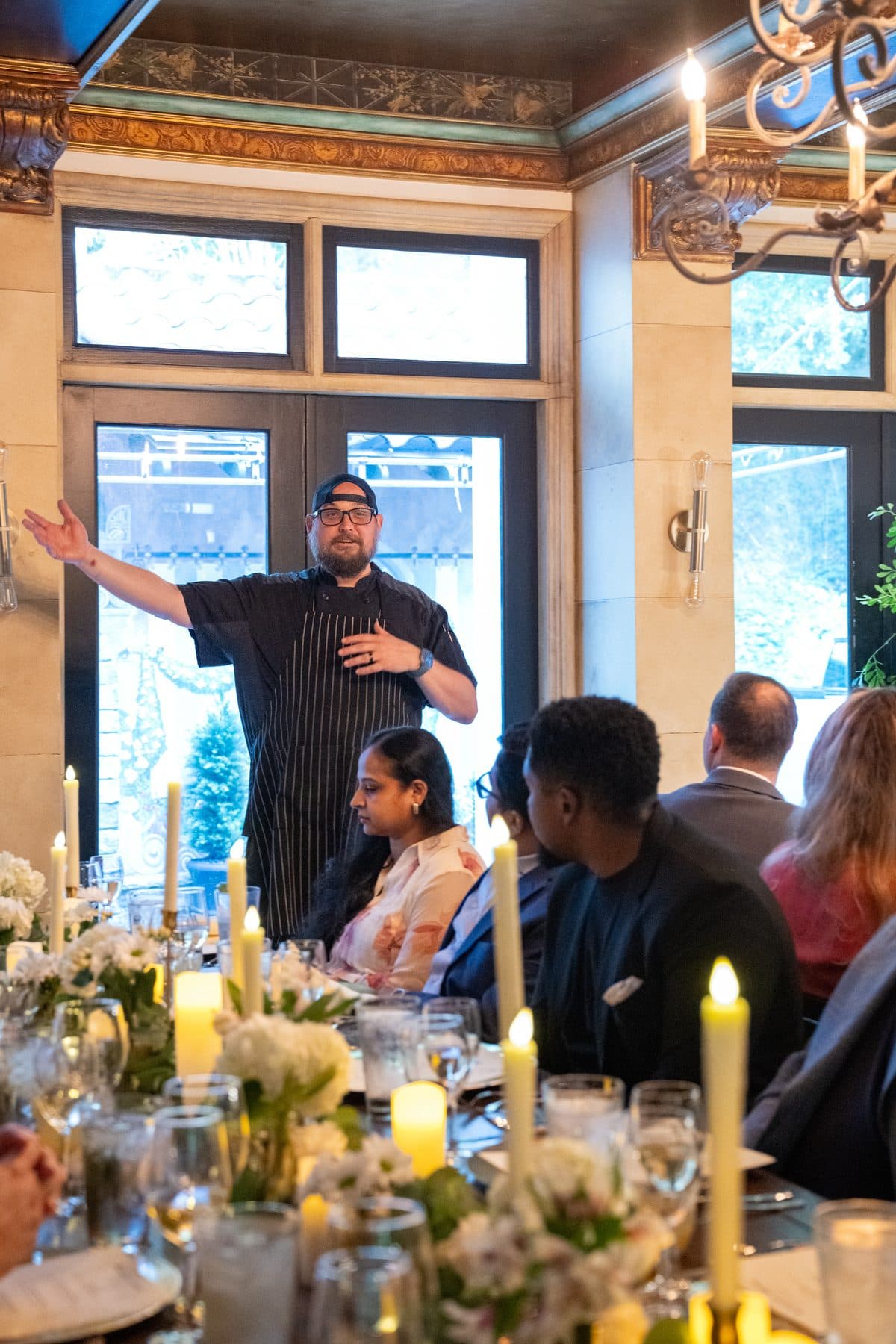 A guest speaker addressing a candlelit dinner