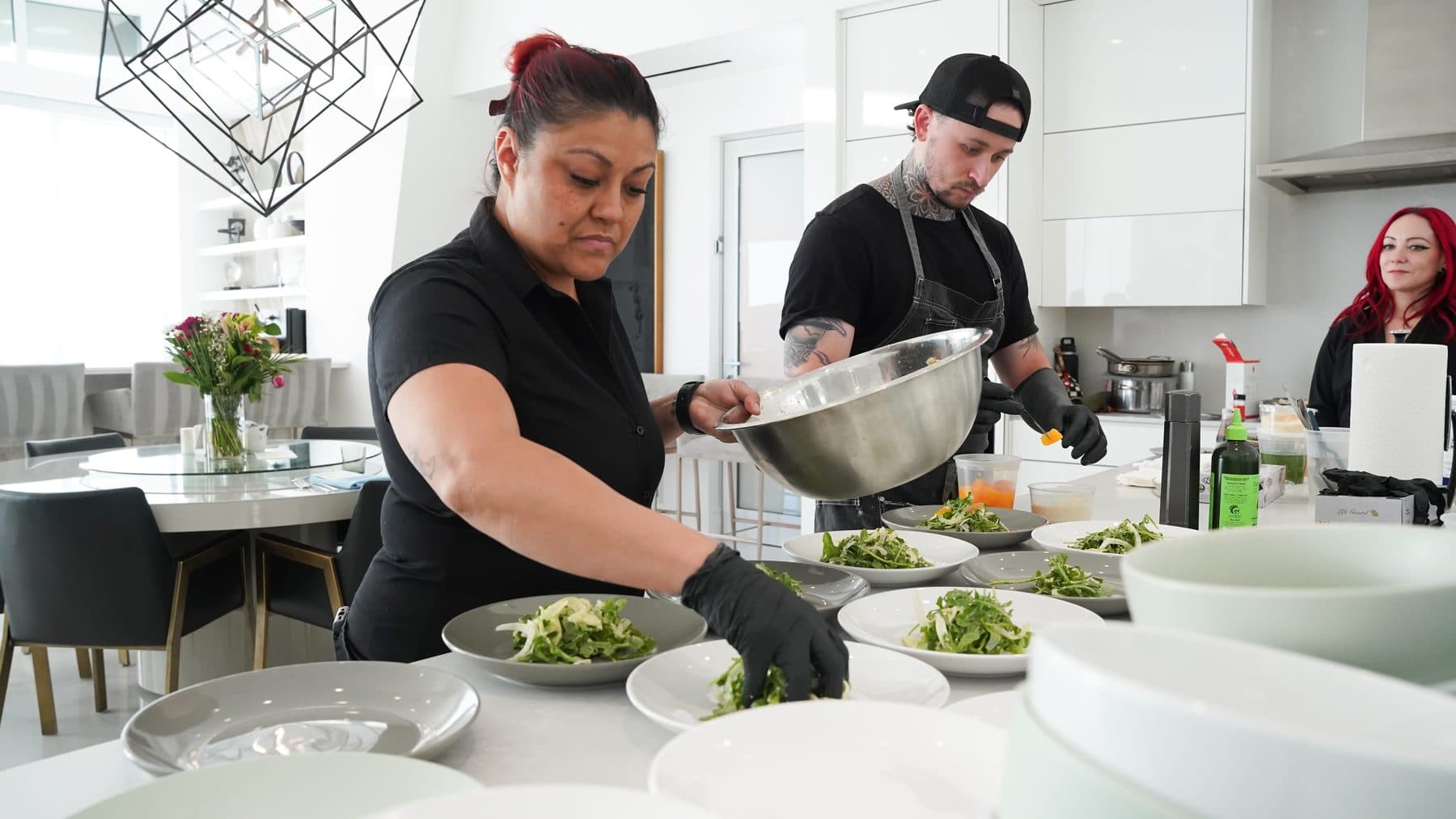 Chefs plating a course in an open kitchen